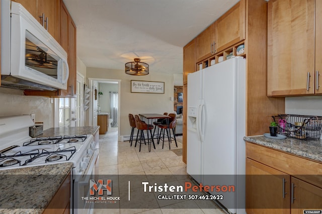 2819 E 6th St, Casper, WY 82609 - kitchen with white appliances, light stone counters, brown cabinetry, and light tile patterned floors