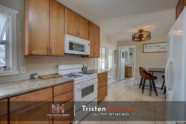 2819 E 6th St, Casper, WY 82609 - kitchen with white appliances, brown cabinets, and baseboard heating