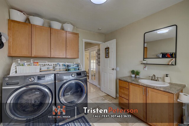 2819 E 6th St, Casper, WY 82609 - clothes washing area featuring washing machine and dryer, cabinet space, and light tile patterned floors