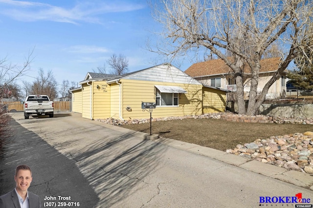 view of side of property featuring driveway and fence