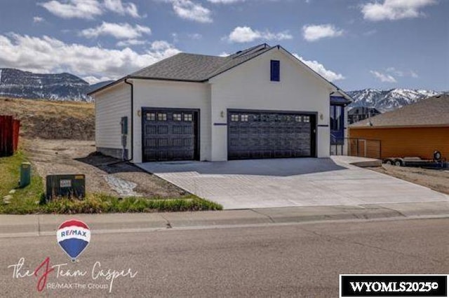 view of front facade with a mountain view, driveway, and an attached garage