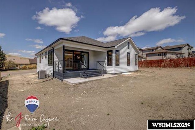 view of front of house featuring central AC, fence, and covered porch
