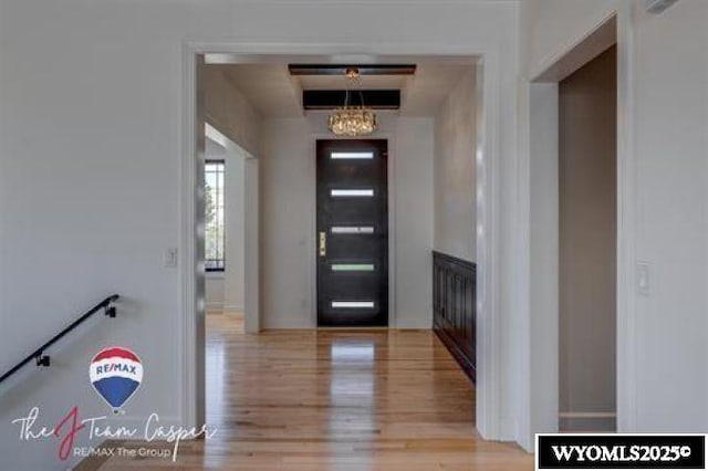entryway with wood finished floors and a chandelier