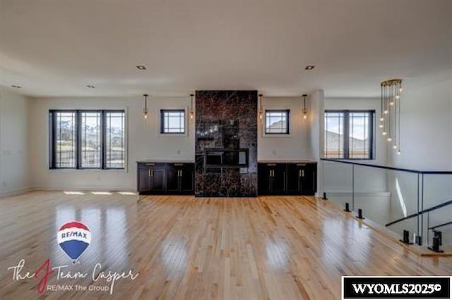 unfurnished living room featuring wood finished floors, a wood stove, and baseboards