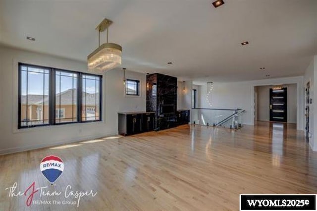 unfurnished living room featuring wood finished floors and baseboards