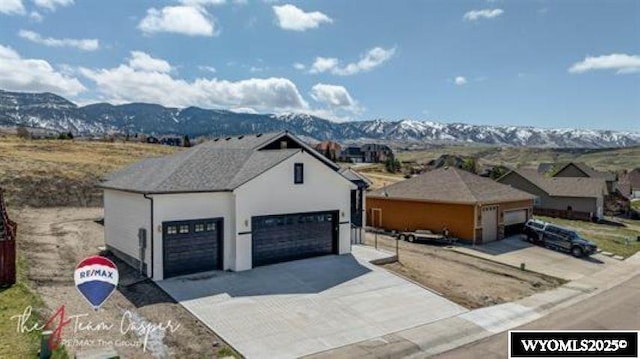 view of front facade featuring a mountain view, a garage, and stucco siding