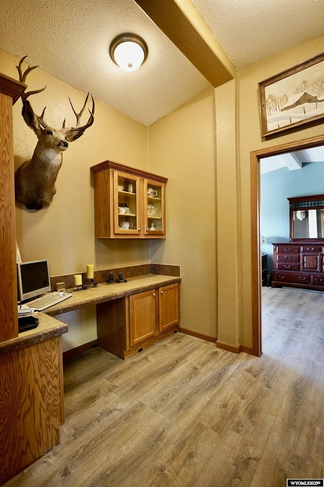 33 Oxbow Rd, Buffalo, WY 82834 - office space with light wood-style flooring, built in desk, a textured ceiling, and baseboards