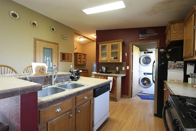 33 Oxbow Rd, Buffalo, WY 82834 - kitchen featuring white dishwasher, stacked washer / drying machine, light wood-type flooring, a sink, and brown cabinets