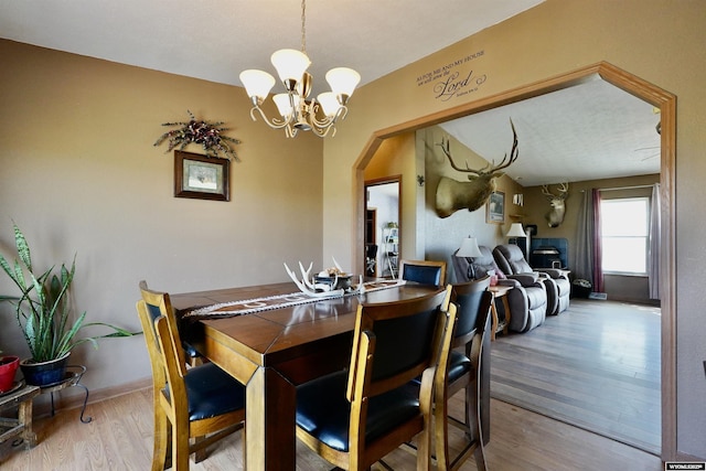 33 Oxbow Rd, Buffalo, WY 82834 - dining room featuring wood finished floors, a chandelier, and arched walkways
