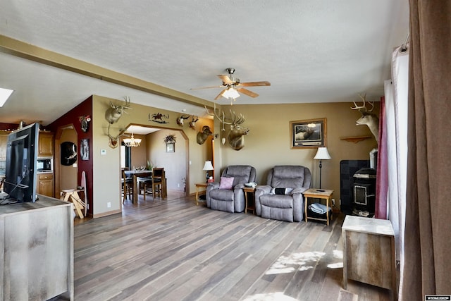 33 Oxbow Rd, Buffalo, WY 82834 - living area featuring light wood-style floors, a textured ceiling, a ceiling fan, baseboards, and a wood stove