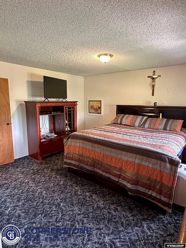 bedroom featuring a textured ceiling and carpet floors