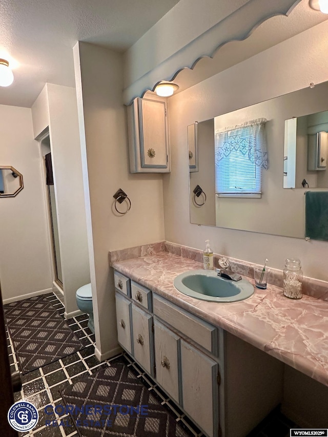 full bath featuring vanity, toilet, and a stall shower