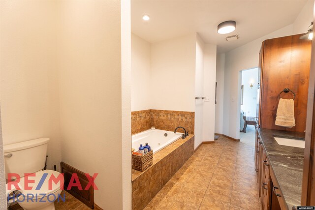 6 Chapparal, Douglas, WY 82633 - full bathroom with a jetted tub, toilet, vanity, and tile patterned floors