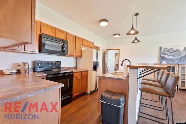 6 Chapparal, Douglas, WY 82633 - kitchen featuring black appliances, a sink, dark wood finished floors, a kitchen bar, and hanging light fixtures