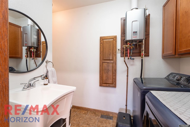 6 Chapparal, Douglas, WY 82633 - laundry area with water heater, cabinet space, baseboards, and washing machine and dryer