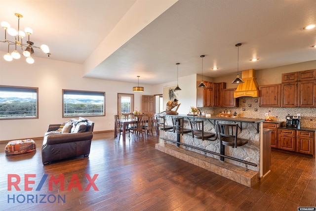 6 Chapparal, Douglas, WY 82633 - kitchen featuring dark countertops, custom exhaust hood, dark wood-style floors, and a kitchen bar