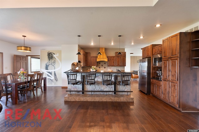 6 Chapparal, Douglas, WY 82633 - kitchen with stainless steel appliances, premium range hood, a kitchen bar, dark wood-style floors, and pendant lighting