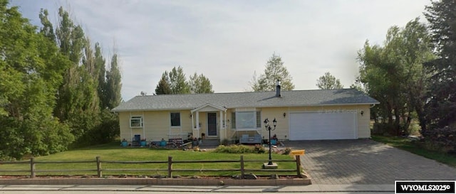 ranch-style home featuring an attached garage and decorative driveway