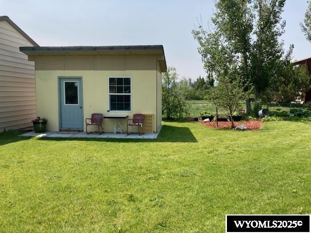 rear view of property with a yard and stucco siding