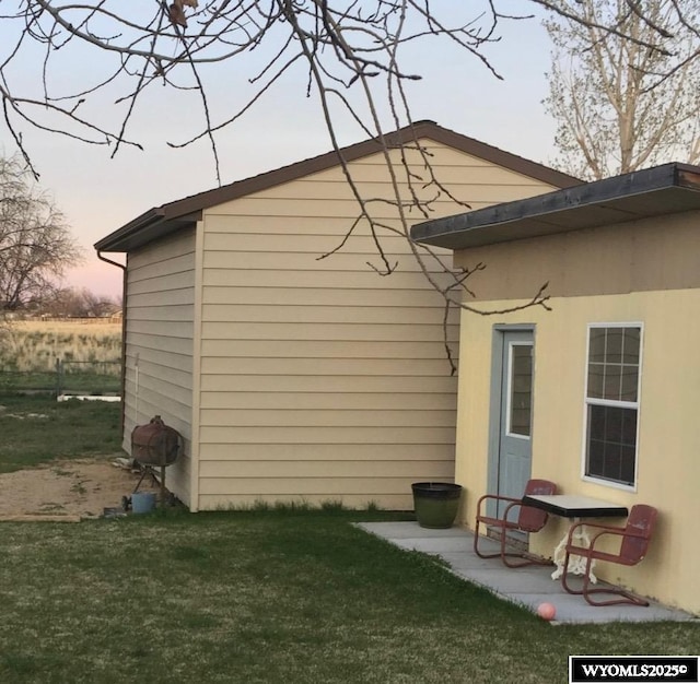 property exterior at dusk with a lawn