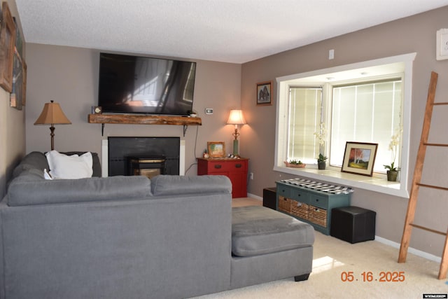carpeted living room with a glass covered fireplace and baseboards