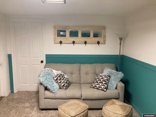 carpeted living area with a wainscoted wall