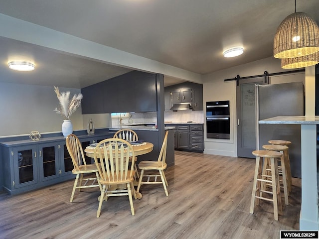 dining space featuring a barn door and wood finished floors