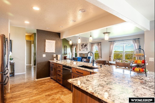 1705 N Heights Cir, Sheridan, WY 82801 - kitchen with a sink, dishwasher, a peninsula, freestanding refrigerator, and light wood finished floors