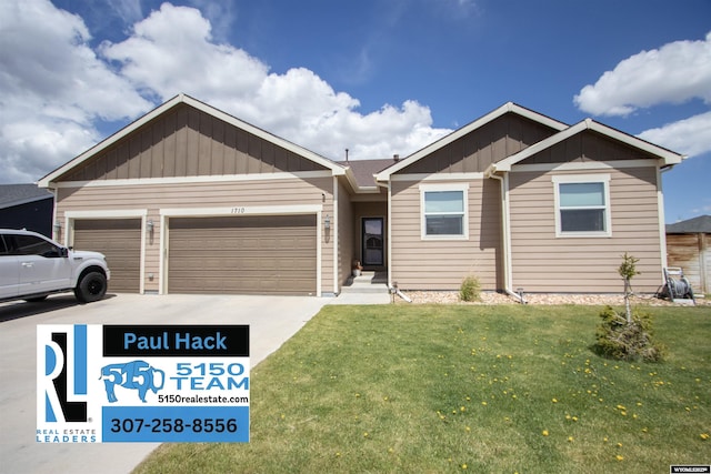 view of front of house featuring board and batten siding, a front yard, an attached garage, and driveway