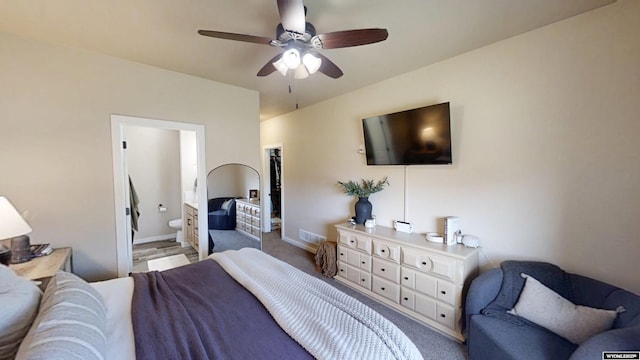 bedroom with baseboards, connected bathroom, and a ceiling fan