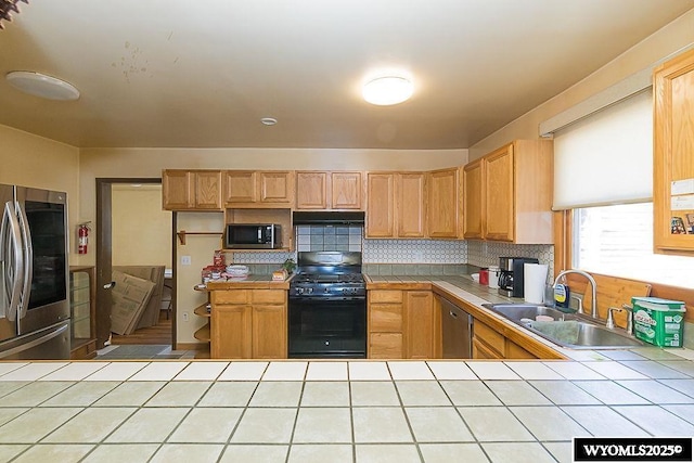 508 Sidney St, Rock Springs, WY 82901 - kitchen with tile counters, appliances with stainless steel finishes, a sink, and tasteful backsplash