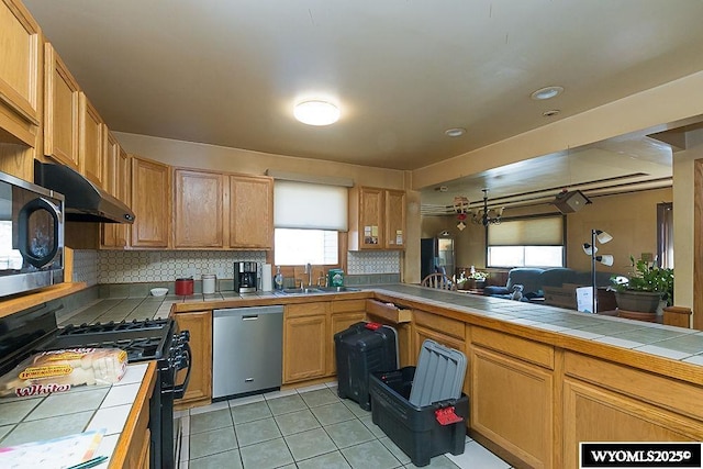 508 Sidney St, Rock Springs, WY 82901 - kitchen with dishwasher, tile countertops, black gas stove, a sink, and recessed lighting