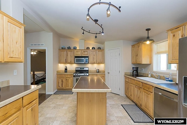 15 Greve Cir, Rock Springs, WY 82901 - kitchen featuring stainless steel appliances, a sink, a center island, and stone tile flooring