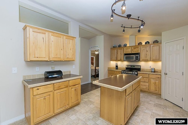 15 Greve Cir, Rock Springs, WY 82901 - kitchen with stainless steel appliances, light brown cabinets, a kitchen island, and baseboards