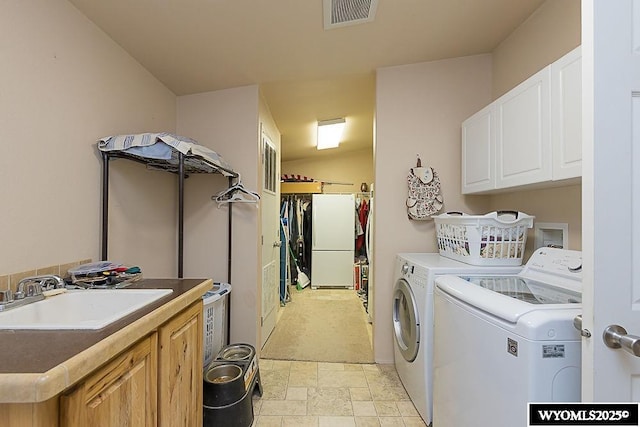 15 Greve Cir, Rock Springs, WY 82901 - laundry area featuring separate washer and dryer, cabinet space, light carpet, and light stone finish flooring