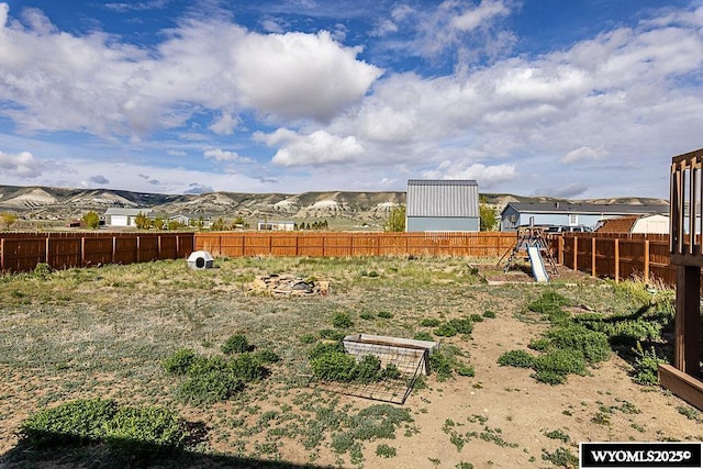 15 Greve Cir, Rock Springs, WY 82901 - view of yard featuring fence, a playground, and a mountain view