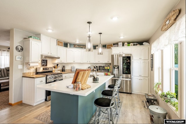 750 N Adams Ave, Buffalo, WY 82834 - kitchen featuring appliances with stainless steel finishes, under cabinet range hood, light wood-style floors, white cabinets, and recessed lighting