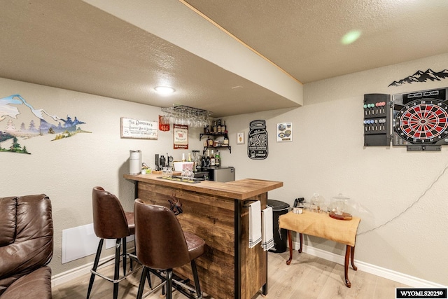 750 N Adams Ave, Buffalo, WY 82834 - indoor bar with baseboards, wood finished floors, and a textured ceiling