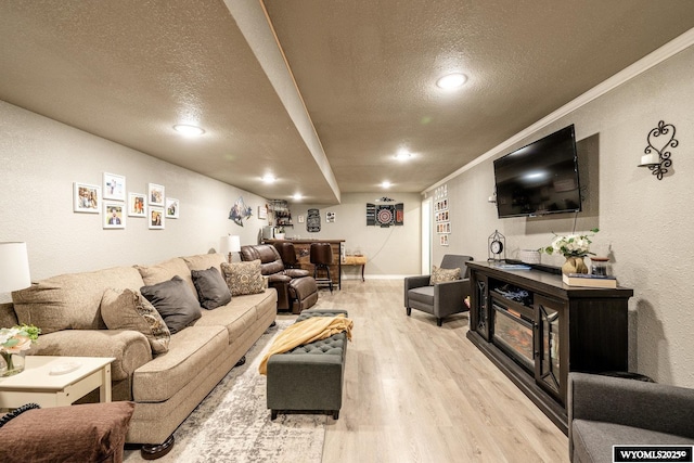 750 N Adams Ave, Buffalo, WY 82834 - living room with a textured ceiling, light wood finished floors, a textured wall, crown molding, and baseboards