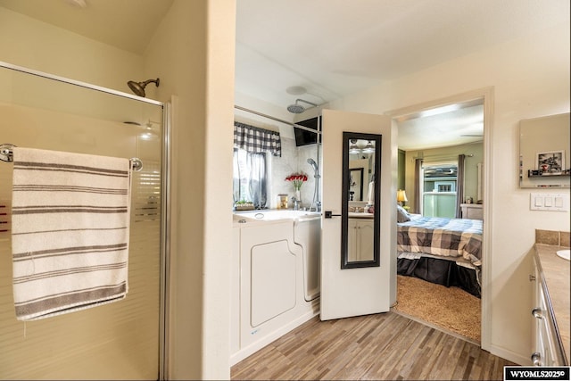 750 N Adams Ave, Buffalo, WY 82834 - full bathroom featuring washing machine and clothes dryer, vanity, a stall shower, wood finished floors, and connected bathroom