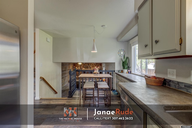 kitchen with dark wood-style floors, appliances with stainless steel finishes, dark countertops, and hanging light fixtures