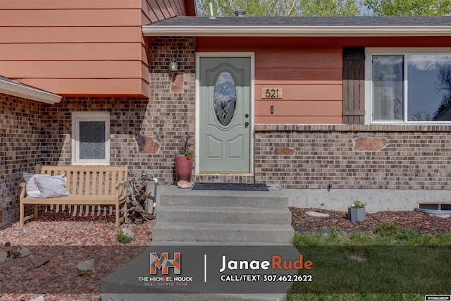 doorway to property with brick siding