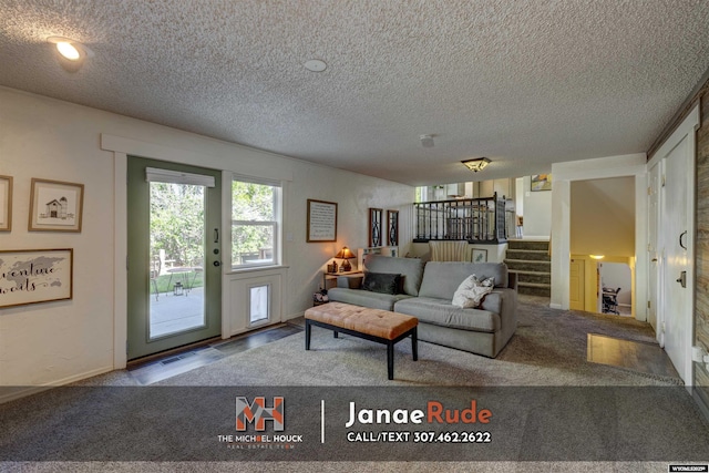 living area featuring stairs, a textured ceiling, and carpet floors