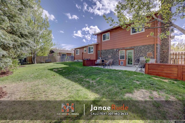 rear view of house with brick siding and a patio
