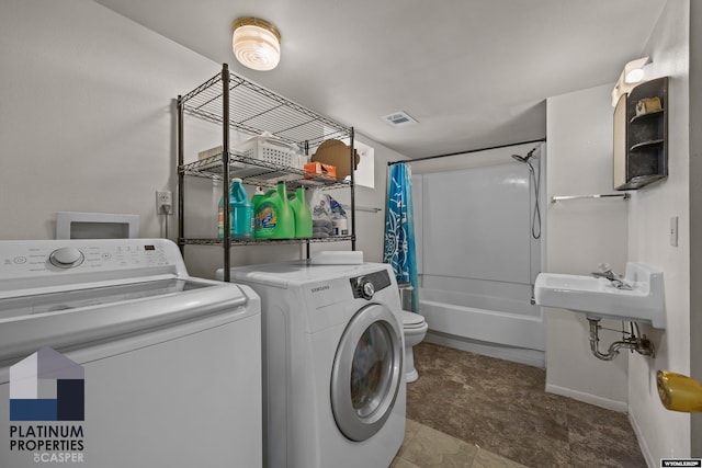 laundry area with washer and dryer and baseboards
