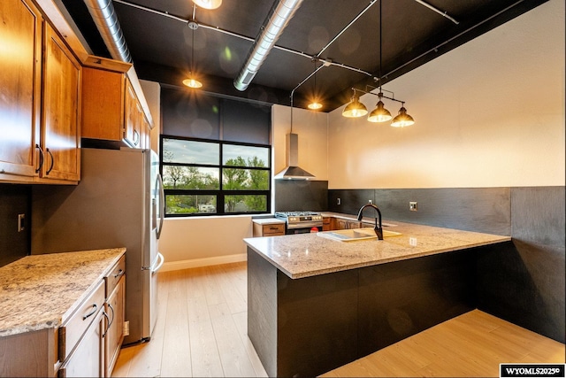 1030 N Main St, Sheridan, WY 82801 - kitchen with wall chimney range hood, a sink, stainless steel appliances, brown cabinetry, and light wood-type flooring