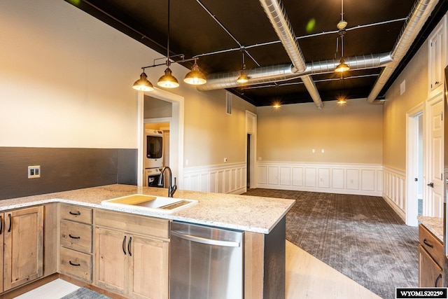 1030 N Main St, Sheridan, WY 82801 - kitchen with stacked washer / dryer, a sink, stainless steel dishwasher, light stone countertops, and wood finished floors