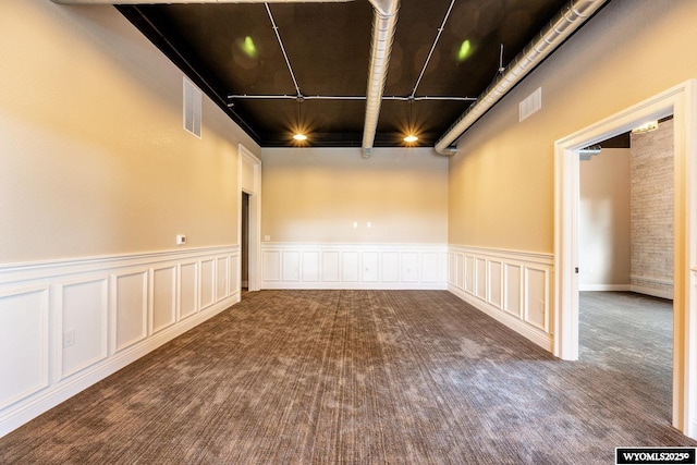 1030 N Main St, Sheridan, WY 82801 - carpeted empty room with a decorative wall and wainscoting