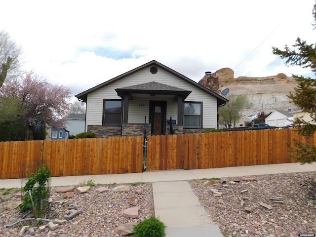 295 N 1st Street E, St, Green River, WY 82935 - bungalow-style house featuring a fenced front yard, a gate, and stone siding