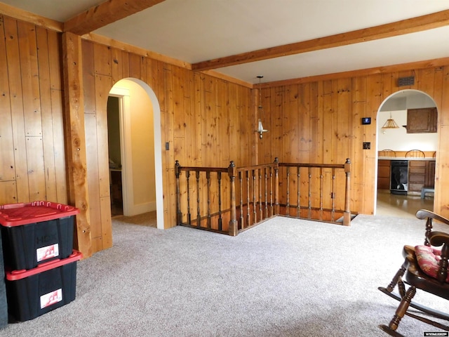 295 N 1st Street E, St, Green River, WY 82935 - sitting room featuring an upstairs landing, beamed ceiling, arched walkways, carpet floors, and wood walls